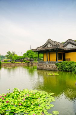 Jiangsu 'da güneşli bir günde, Çin' in Wuxi şehrindeki Turtle Adası 'nın Taihu ya da Taihu Gölü' ndeki küçük bir havuz üzerinde Çin yapımı bir bina..