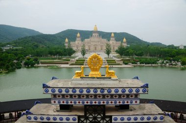 Jiangsu 'daki Wuxi Çin' in Lingshan Scenic bölgesinde Sangharam bo da la Budist binasının arka planında altın heykeller var..  