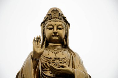 Çin 'in Zhejiang eyaletindeki Putuoshan adasındaki Guanyin Buda heykeli bulutlu bir arka planda.. 