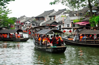 8 Ağustos 2015. Xitang Su Şehri, Çin. Çin 'in Zhejiang Eyaleti' ndeki Xitang kasabasının su kanallarında kalabalık turist tekneleri bulutlu bir günde. 