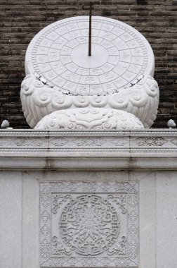 Çin 'in Shaanxi eyaletinde yer alan Xian şehir duvarının güney kapısında bulunan antik bir taş güneş saati. Geleneksel Çin karakterleri zamanı temsil ediyor.. 