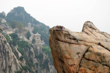 San Huang Zhai Manastırı 'nın bulanık arka planına sahip büyük bir kaya, Çin' in Henan Eyaleti Dengfeng şehri yakınlarındaki Mount Song 'un (şarkı) tepesinde.. 