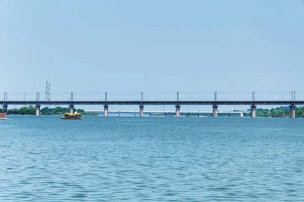 Henan eyaletindeki Luoyang Çin 'de Yi Nehri' ni geçen yüksek hızlı bir tren köprüsü yakınında bir turist teknesi.. 