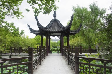 Jiangsu, Çin 'in Zhenjiang bölgesindeki Jinshan Tapınağı' nın manzaralı alanındaki bir taraçanın yakınındaki nilüfer çiçekleri arasında bir yürüyüş..