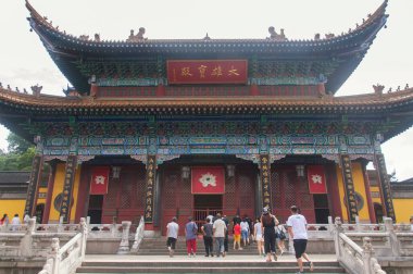 Zhenjiang, Çin. 12 Ağustos 2017. Çinli turistler Jiangsu, Çin 'in Zhenjiang şehrinde bulutlu bir günde Jinshan Tapınağı' ndaki büyük Buda salonunu ziyaret ediyorlar..