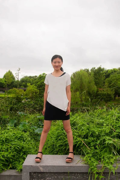 Een Blije Chinese Vrouw Staand Een Muur Met Een Natuur — Stockfoto