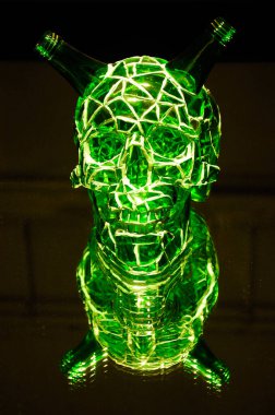 Aynada oturan yeşil bir cam kafatası görüntüyü yansıtarak bir kopyasını yaratıyor.. 