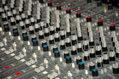 Ses karıştırma tahtasındaki tuşlara, anahtarlara, düğmelere ve kollara yakın çekim.