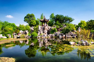 Çin çardağı ve insan yapımı bir gölet. Luzhi antik kasabasında. Jiangsu şehrinin Wuzhong bölgesinde güneşli mavi bir gökyüzü gününde..