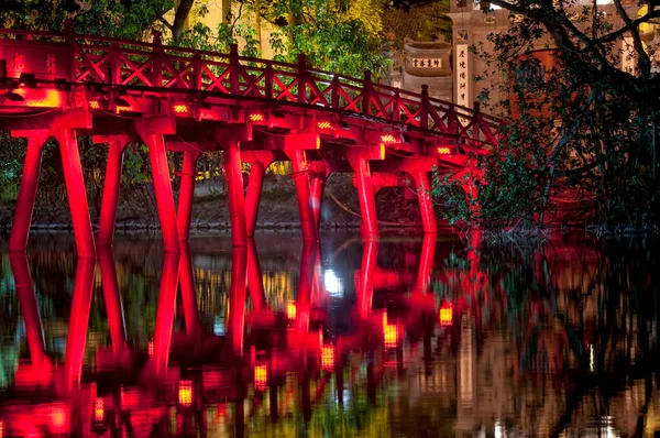 Hanoi Vietnam 'daki Hoan Kiem Gölü' ndeki Yeşim Dağı 'nın Budist Tapınağı' na giden Huc Köprüsü 'nün gece sahnesinde kırmızı ışık yandı..