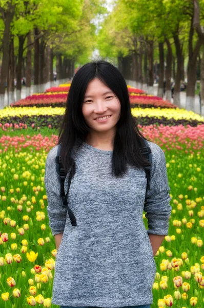 上海一位中国妇女笑着站在一片郁金香面前 — 图库照片