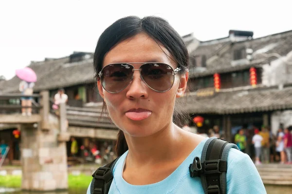 浙江省嘉山县 一名中国妇女在西塘水镇的相机前伸出舌头 但在拍摄的背景下却模糊不清 — 图库照片