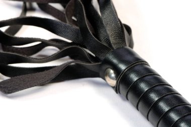 Sadomazoşizm ve hakimiyette kullanılan rollerde kullanılan beyaz bir arka planda siyah deri kamçı..