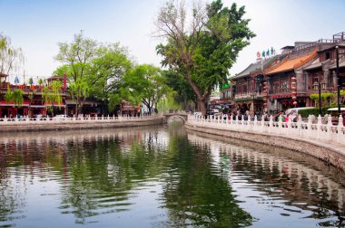 Pekin, Çin. 27 Nisan 2016. Pekin porselenlerinin Hutong manzaralı bölgesinde, Qianhai gölünün her iki yakasını da çevreleyen çeşitli restoran ve barlar bulutlu bir günde.