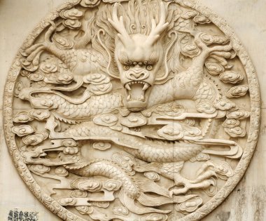 Harbin Çin 'deki bir duvarda taştan oyulmuş bir Çin ejderhası..  