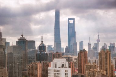 shanghai, china.  July 8, 2016.  The iconic oriental pearl and shanghai towers and financial center rising above lujiazui in pudong side of shanghai china against a stormy cloudy sky.