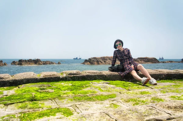 Happy Chinese Woman Sitting Rocky Shore Fushan Bay Qingdao China — Stockfoto