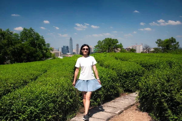 在一个阳光明媚的蓝天 一个快乐的中国女人在中国绍兴市东湖风景区的一个绿茶田前挽着她的裙子 — 图库照片