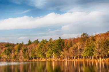 Burr Pond Eyalet Parkı manzarası ve New England 'da güneş batarken Torrington, Connecticut' ta ilkbahar öncesi yansıması. 