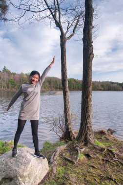 Torrington Connecticut 'taki Burr Pond Eyalet Parkı' nda, bir kayanın üzerinde duran Çinli bir kadın..