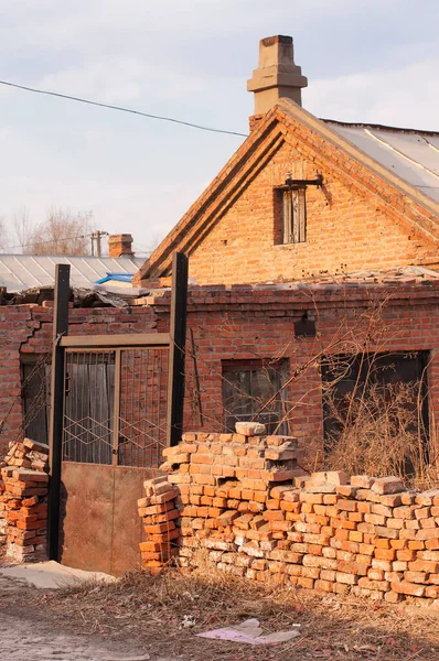 A crumbling brick wall around a home in the city of zhaodong china on an overcast suuny day in heilongjiang province.