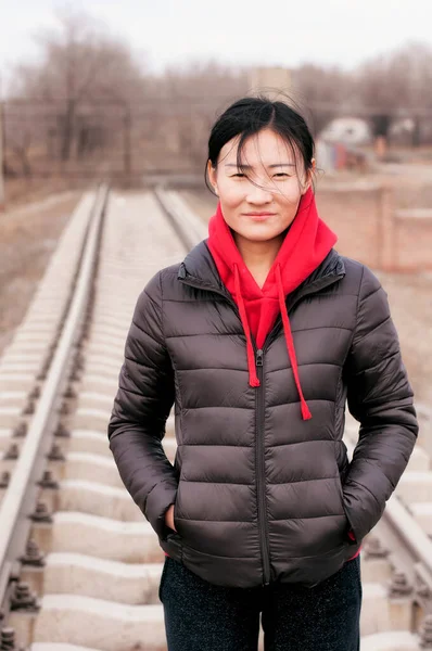 Μια Γυναίκα Μαύρο Σακάκι Και Κόκκινη Κουκούλα Στέκεται Στις Σιδηροδρομικές — Φωτογραφία Αρχείου