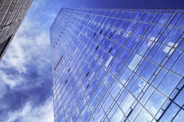 Şenzen Çin 'inde güneşli bir günde güneş ışığını ve gökyüzünü yansıtan modern cam yapılar..