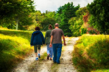 Litchfield, Connecticut.  September 9, 2017.  Grandparents walking with their granddaughter on a path within Topsmead State park in Litchfield connecticut on a sunny day.