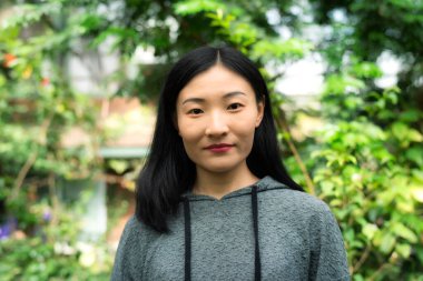 Güney Deerfield Massachusetts 'te, kelebek konservatuarındaki tropik bir seranın içinde gülümseyen Çinli bir kadın..