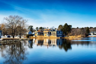 Soğuk, güneşli bir kış gününde, Kennebunkport Maine 'deki Batson Nehri' nin sularından yansıyan büyük bir malikane.. 