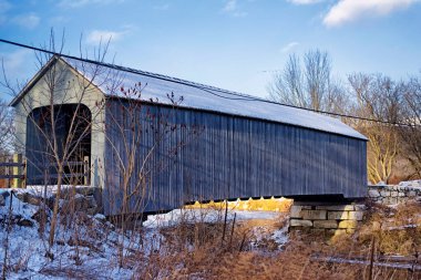 The historic sheffield massachusetts covered bridge spanning the Housatonic River on a cold winter day.