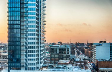 Günbatımında kışın Şikago şehrinin üzerinde yükselen modern bir gökdelen..