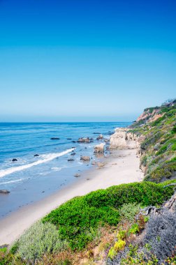 The waves and pacific ocean at El Matador Beach in California on a sunny cloudless sky day.