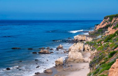 The waves and pacific ocean at El Matador Beach in California on a sunny cloudless sky day.