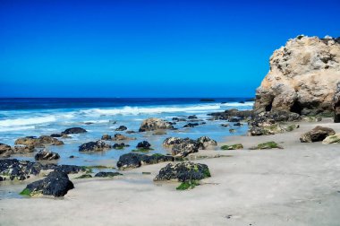 Kaliforniya 'daki El Matador Plajı' nda güneşsiz bir gökyüzünde dalgalar ve Pasifik Okyanusu..