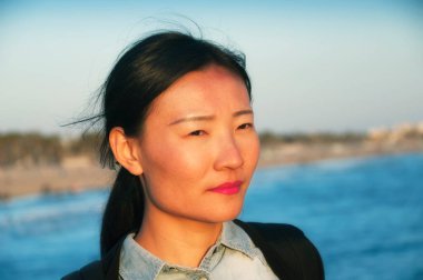 Gün batımında, Santa Monica İskelesi Kaliforniya 'da Pasifik Okyanusu' nun kıyısına bakan Çinli bir kadın..