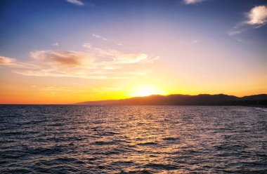 Güneş, batı kıyısındaki dağların üzerinden Santa Monica California ve Pasifik Okyanusu 'nda batıyor..