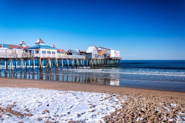 Maine 'deki Old Orchard Plajı. 17 Şubat 2018. New England 'da güneşli bir kış gününde Maine' de karla kaplı ikonik eski meyve bahçesi plajı ve iskele..