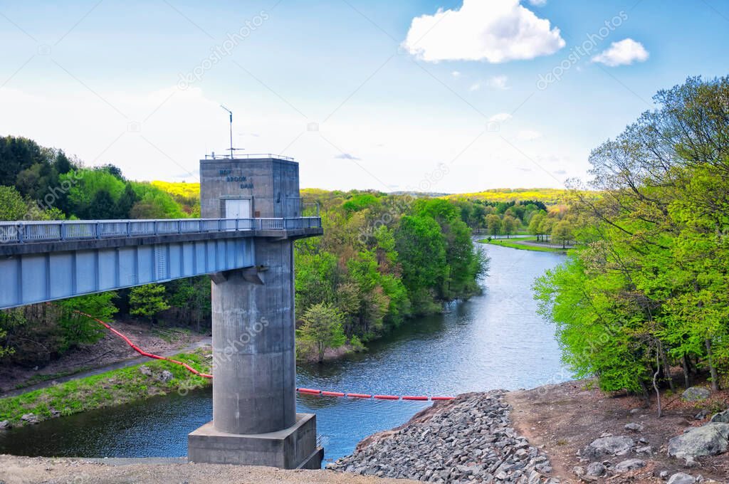 The lake side of Hop Brook Dam in Naugatuck connecticut on a sunny blue sky day.