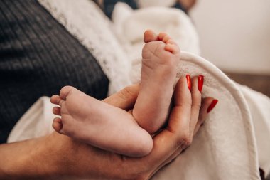 Dişi elinde yeni doğmuş bir bebeğin bacakları. 