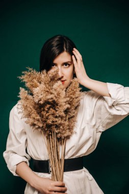 Yeşil arka planda güzel bir kadının stüdyo fotoğrafı. 