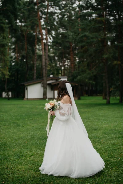 The bride in a wedding dress in nature