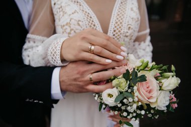 Çiçeklerin arka planında güzel tırnakları olan bakımlı eller.