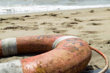 Sahildeki kırmızı renkli can simidine yaklaş.