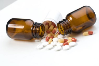 Şişeden haplar ve kapsüller düşüyor.