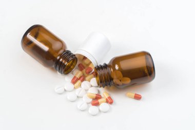 Şişeden haplar ve kapsüller düşüyor.