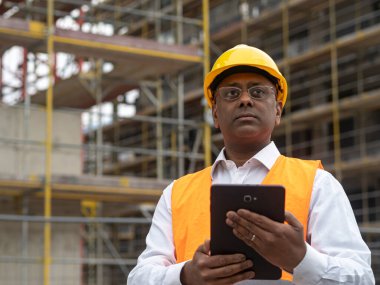 Dijital tablet bilgisayarını elinde tutan Hintli mühendis.