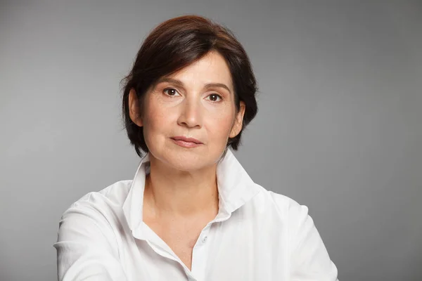 Beyaz gömlekli orta yaşlı kadın portresi..