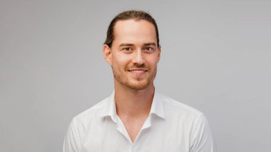 Genç sarışın sakallı adam portresi, modaya uygun saç stili, beyaz gömlekli, gülümseyen ve kameraya bakan. Kafkas portresi beyaza izole edilmiş..