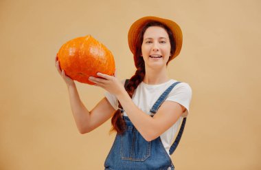 Çiftçi kadın sonbahar hasadından memnun ve olgun bir balkabağı besliyor.